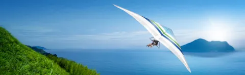 Man flying hangglider on the coast
